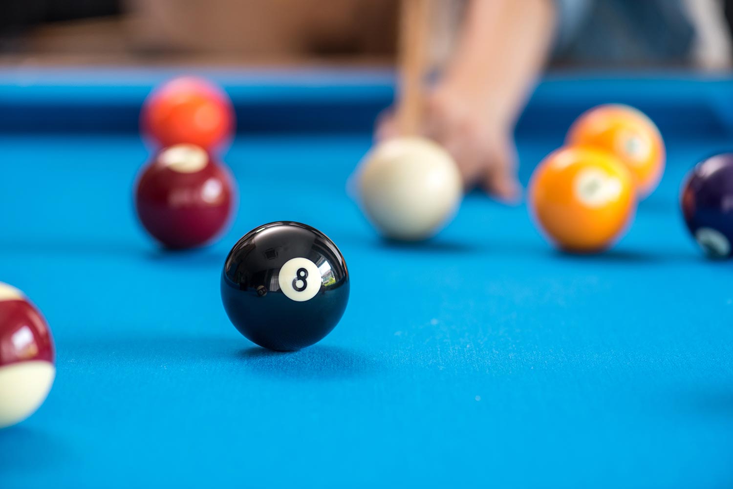 pool or billiards balls on light blue table , focus on number 8